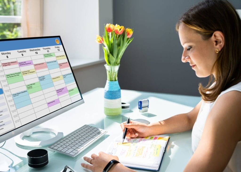 Woman planning schedule with digital and paper calendars.