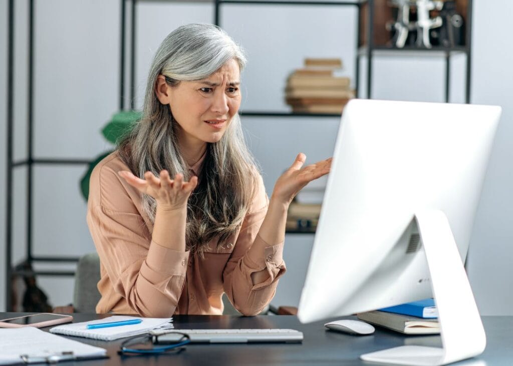 Confused woman with computer in modern office.