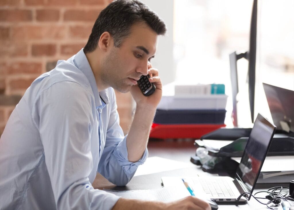 Man on phone in modern office setting.