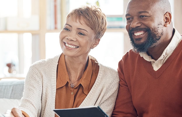 Happy couple looking at digital tablet together.