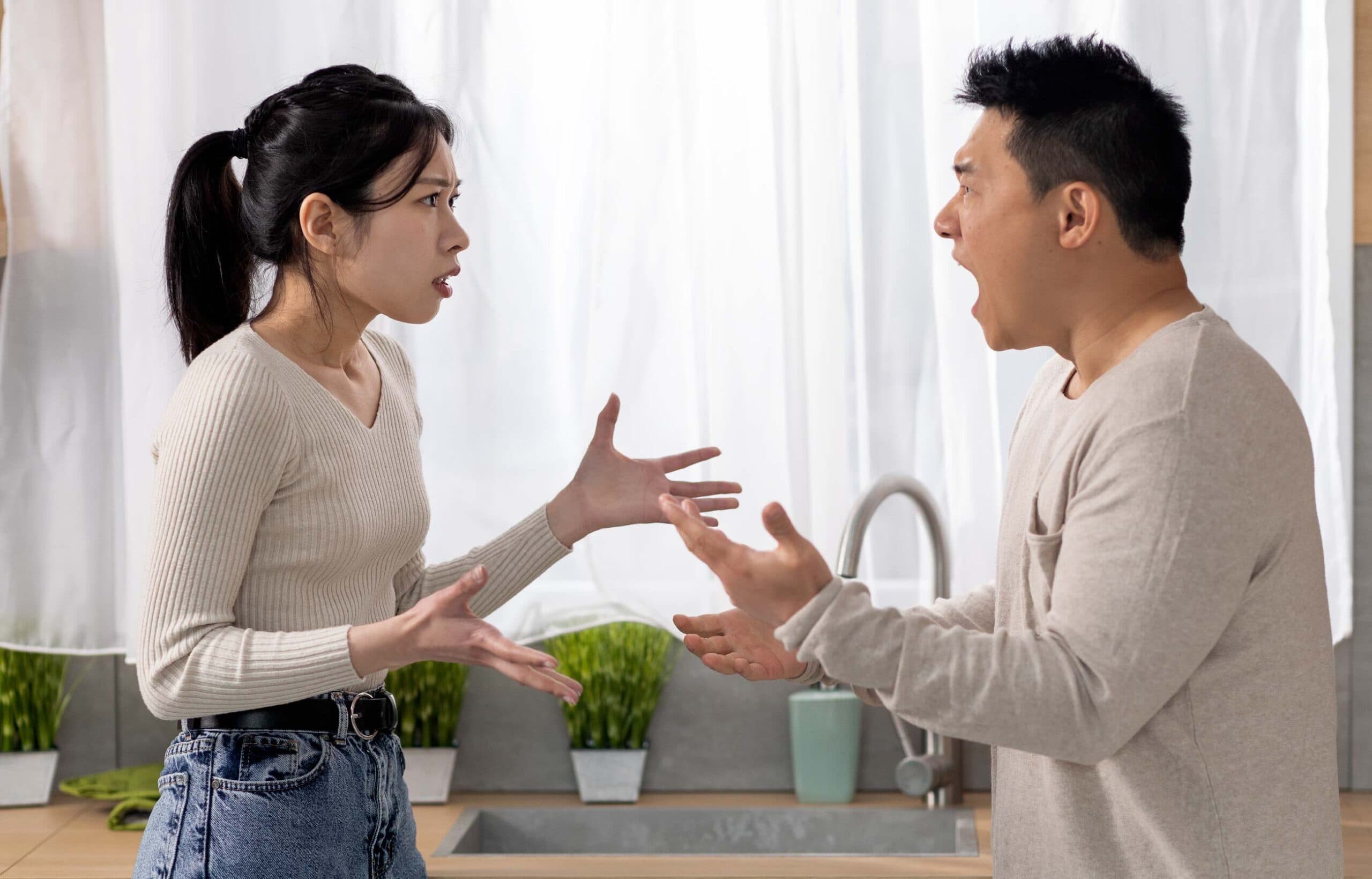 Couple arguing intensely in kitchen.