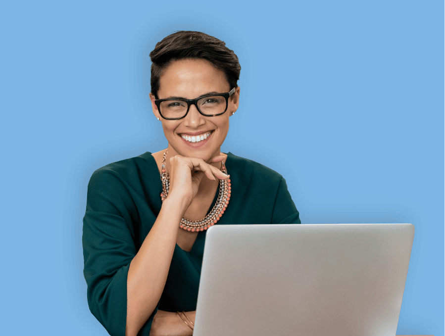 Smiling woman with glasses using laptop.
