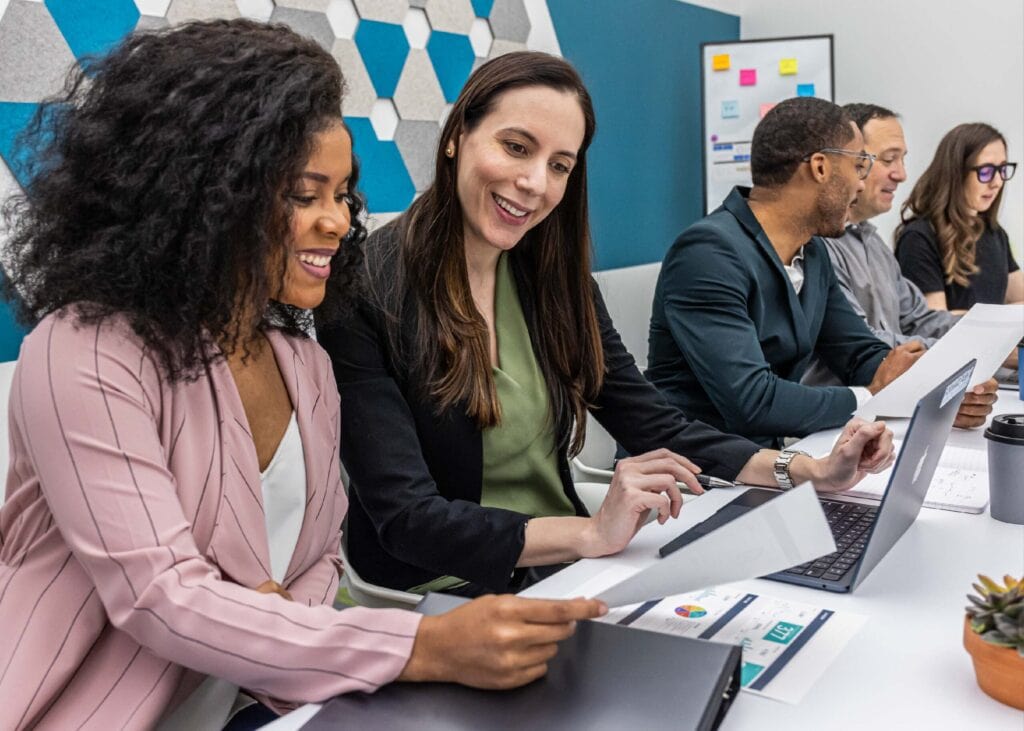 Diverse team collaborating happily in modern office setting.