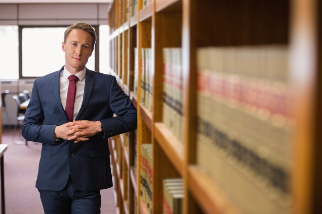 Man in suit standing in library aisle