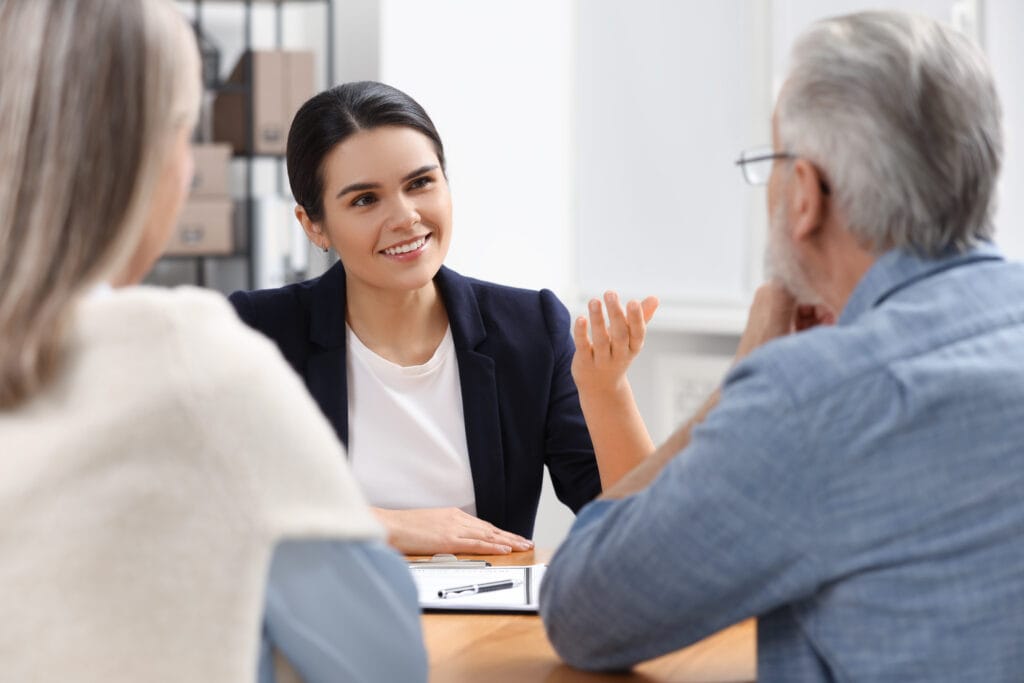 Businesswoman discussing with elderly couple in office