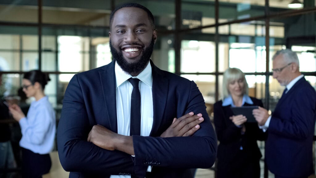 Confident businessman smiling in office lobby