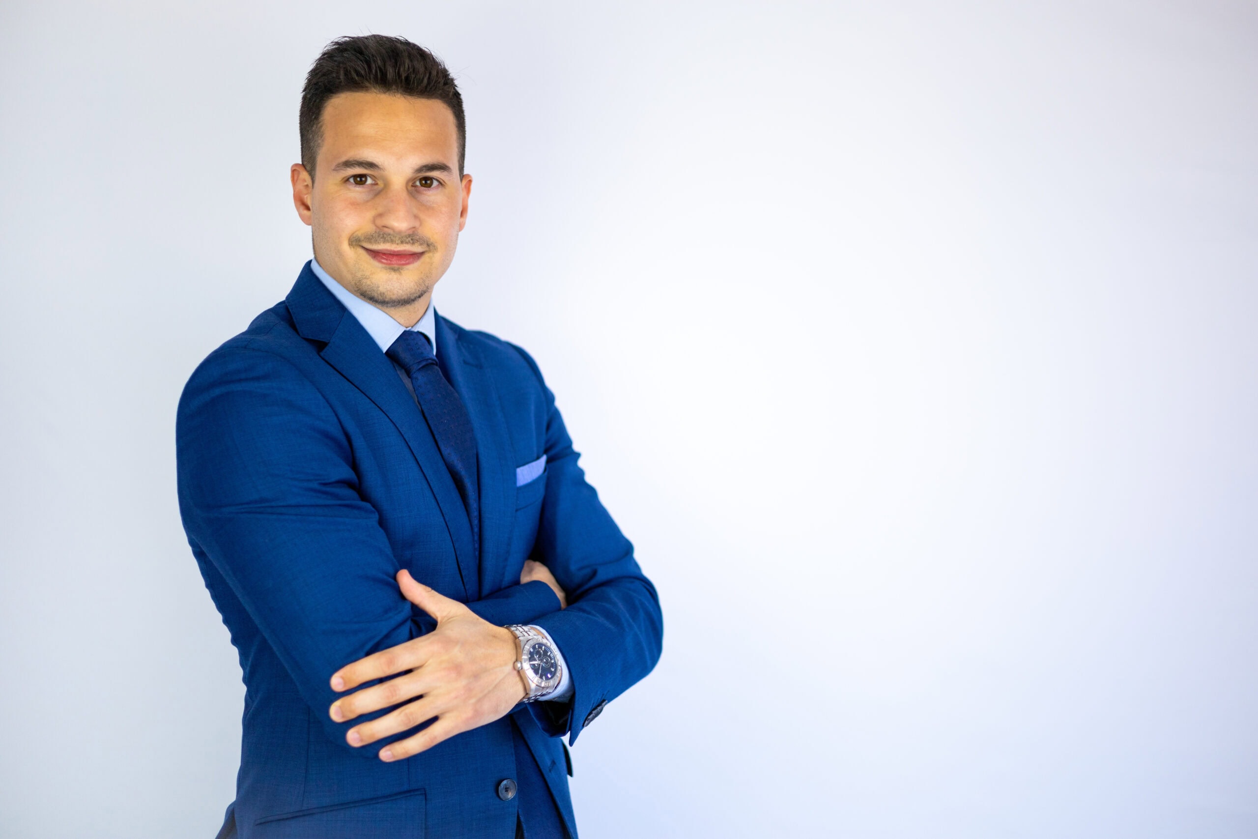 Confident man in blue suit smiling against white background