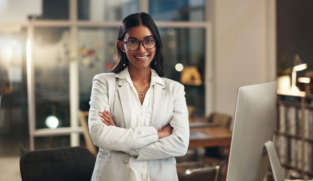 Confident woman in office smiling at camera