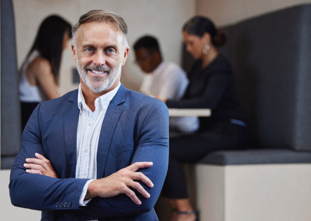 Confident senior businessman smiling in office setting