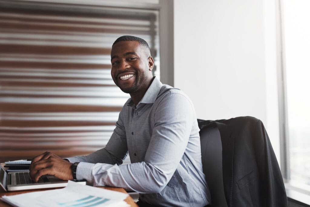 Smiling businessman sitting at desk in office