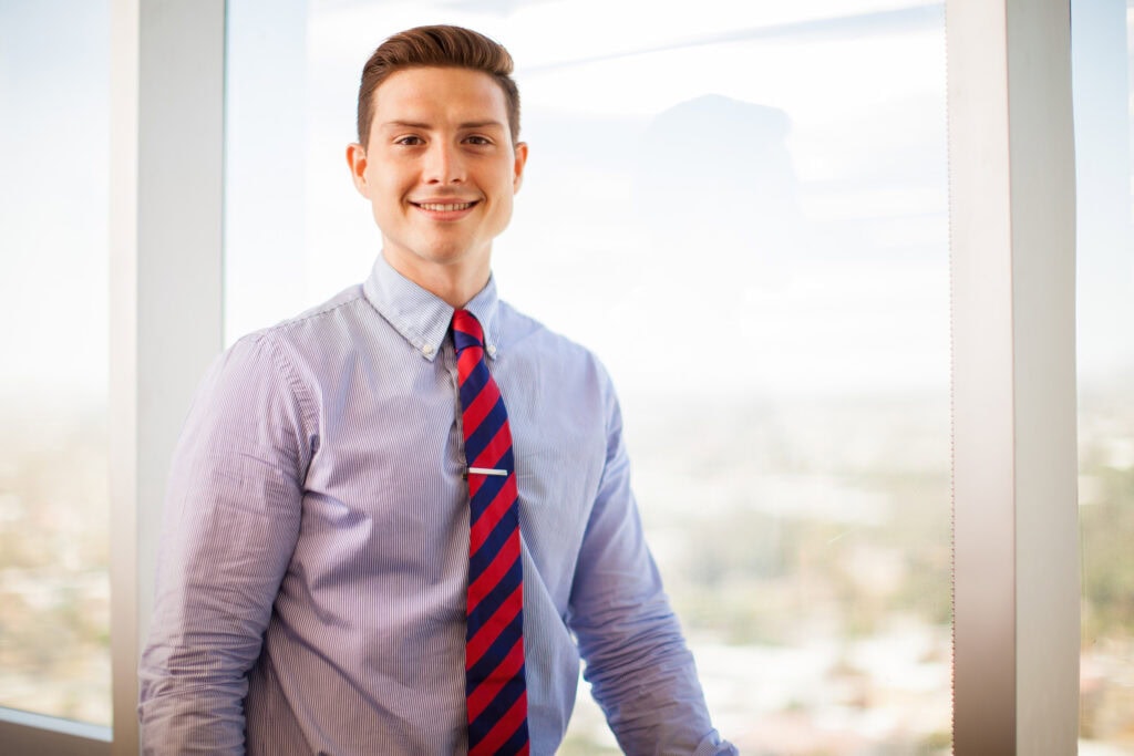 Smiling professional man in office with city view