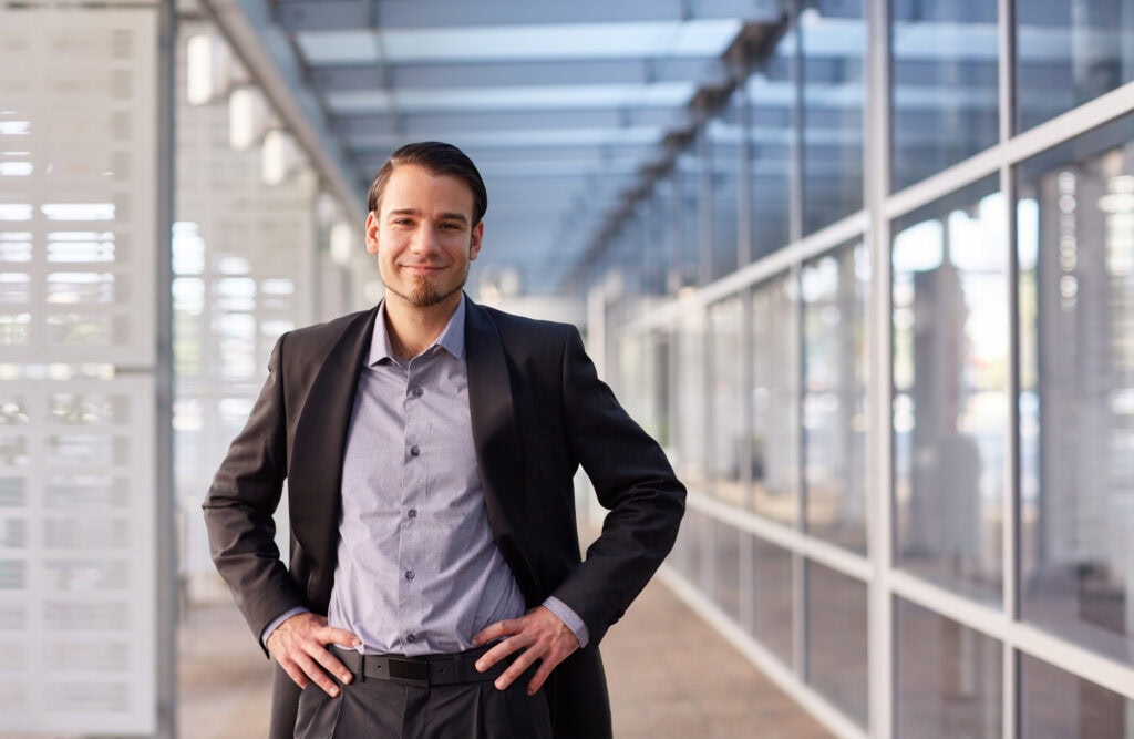 Professional man smiling in modern office corridor