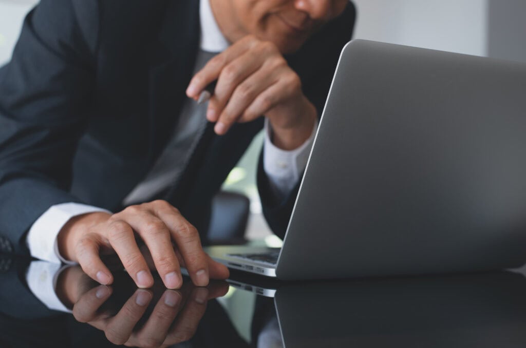 Businessman consulting laptop for guidance