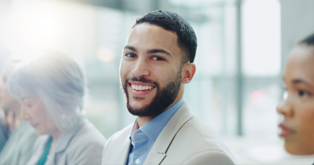 Confident young businessman smiling in office setting
