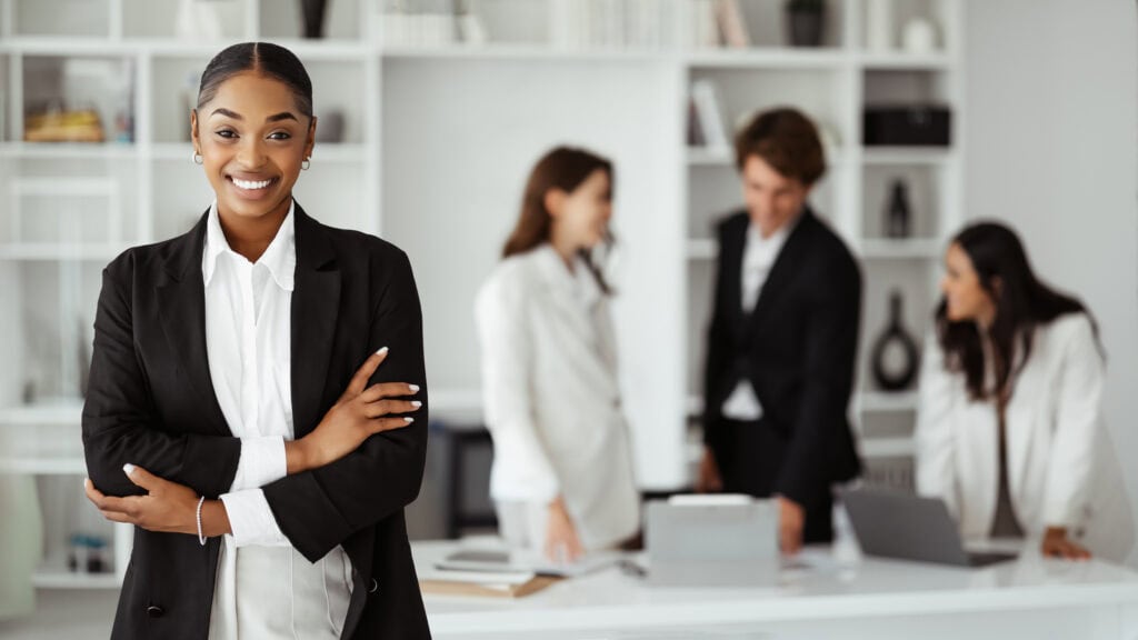Confident businesswoman with team in background