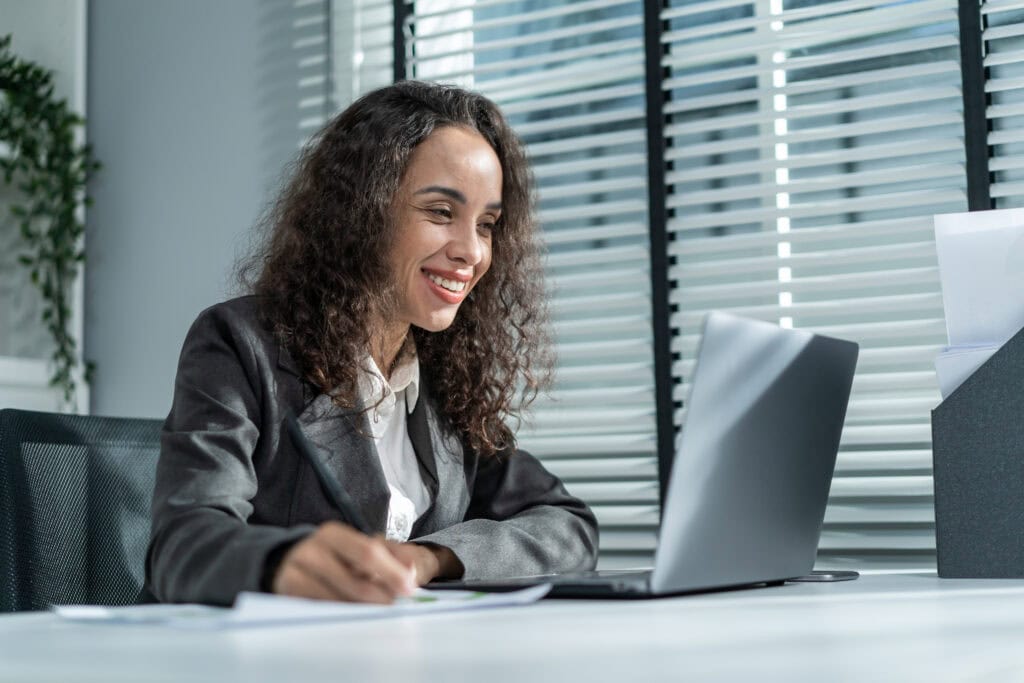 Smiling woman working on laptop in office