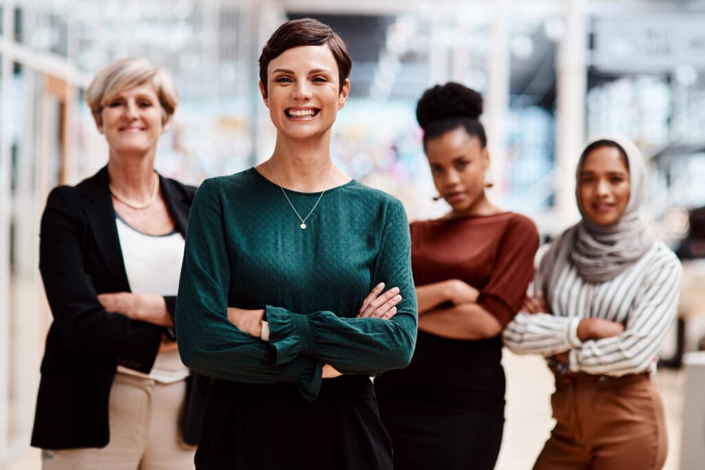 Diverse professional women confidently standing together in office