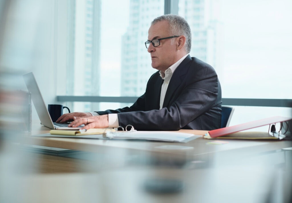 Businessman working on laptop in modern office setting