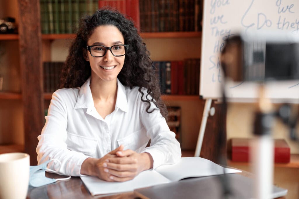 Smiling woman with glasses teaching online