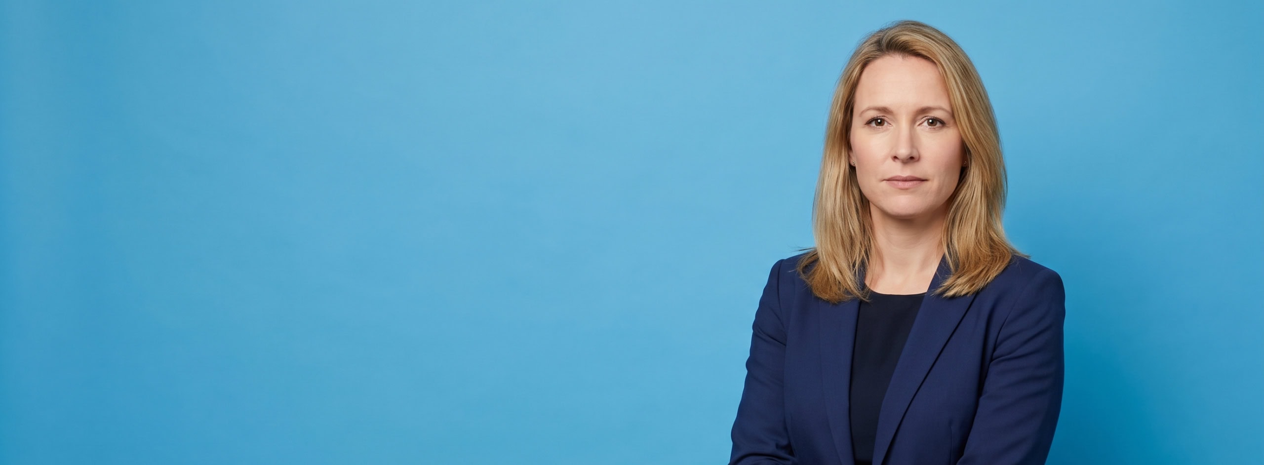 Professional portrait on blue studio background - Why Your Competitor Shows Up in AI Search (And You Don't)