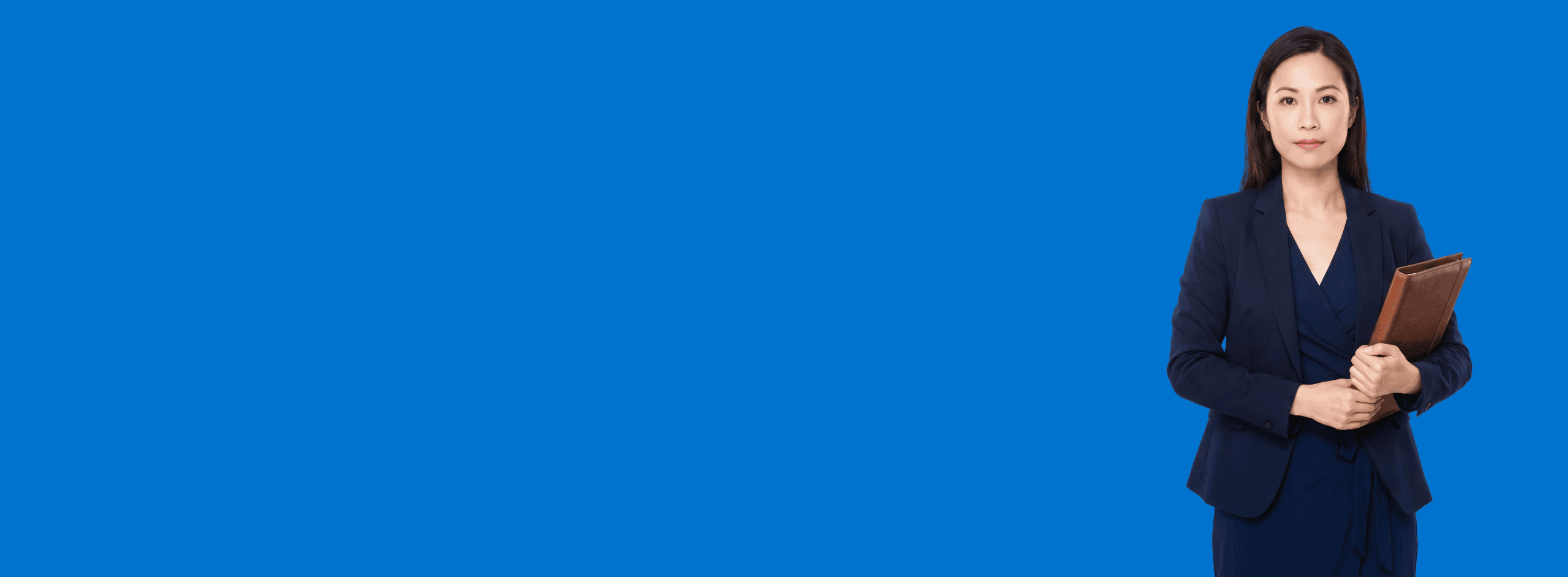 Asian female attorney, 30s, slim build in navy wrap dress with structured blazer, portrait against a saturated blue background - I Asked ChatGPT to Recommend an Attorney in My City. Here’s What Happened.