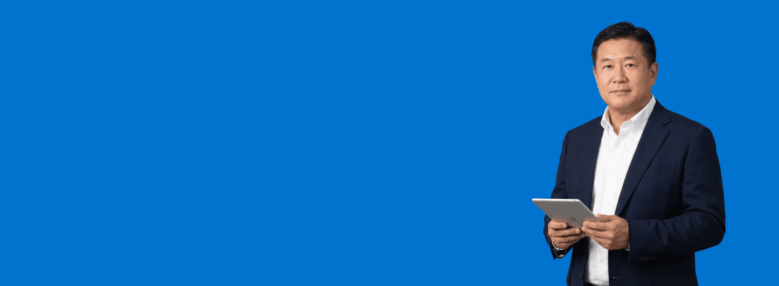 Asian male attorney, 50s, broader build in dark navy blazer and white open-collar shirt, portrait against a saturated blue background - Your Website Has Visitors Who Will Never Call. Sidebar AI Is How You Reach Them.