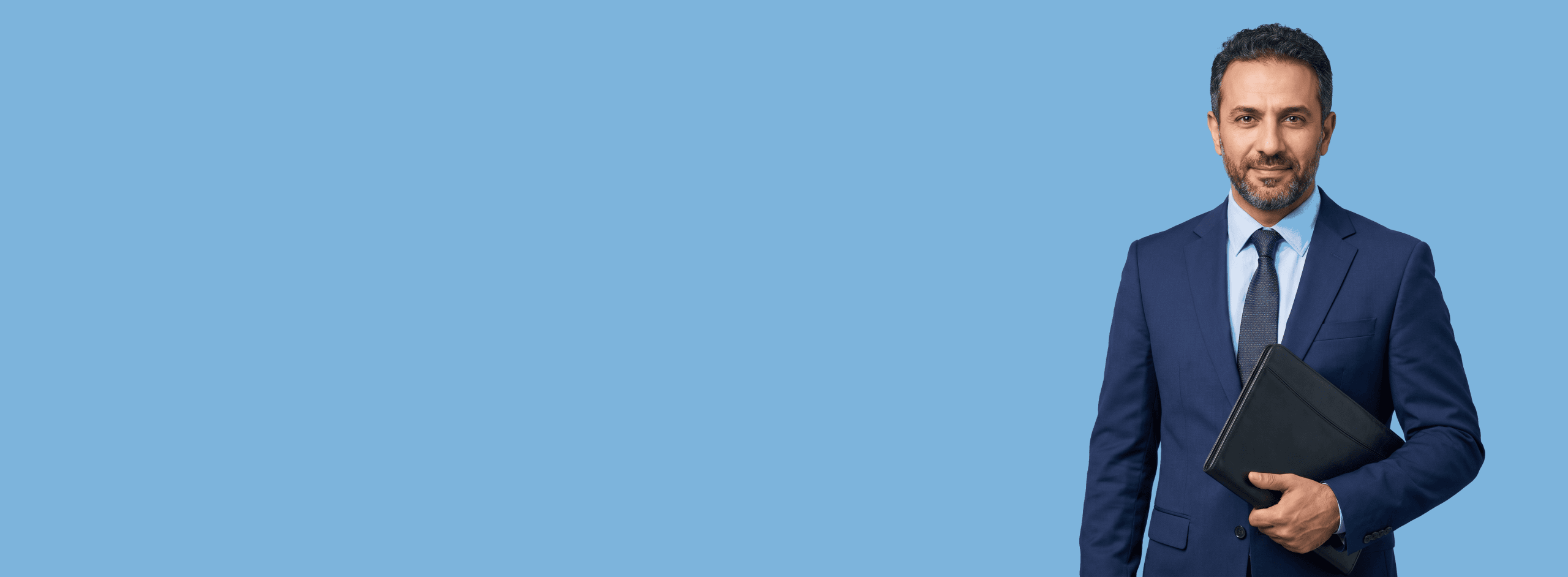 Middle Eastern male attorney, 40s, average build in navy suit with pale blue shirt, portrait against a light blue background - The Saturday Call