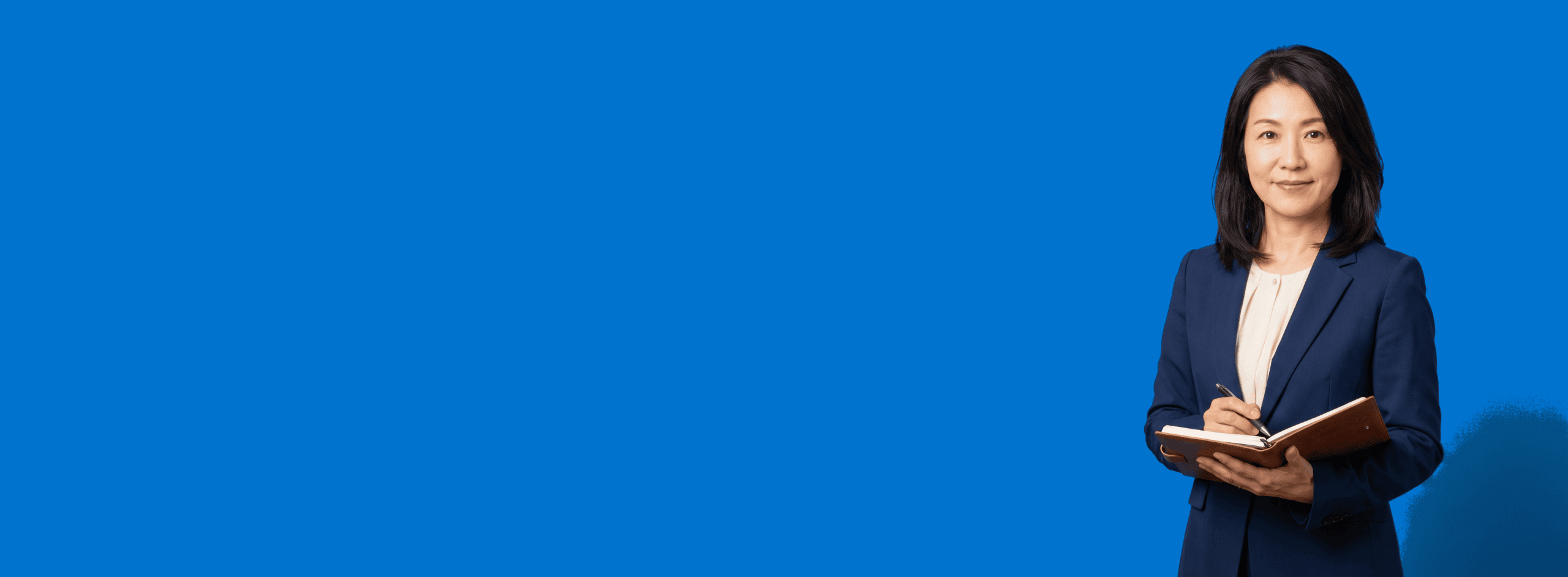 Asian female attorney, 40s, average build in navy blazer with cream blouse, portrait against a saturated blue background - Why Attorneys Stop Making Videos And the System That Makes Stopping Unnecessary