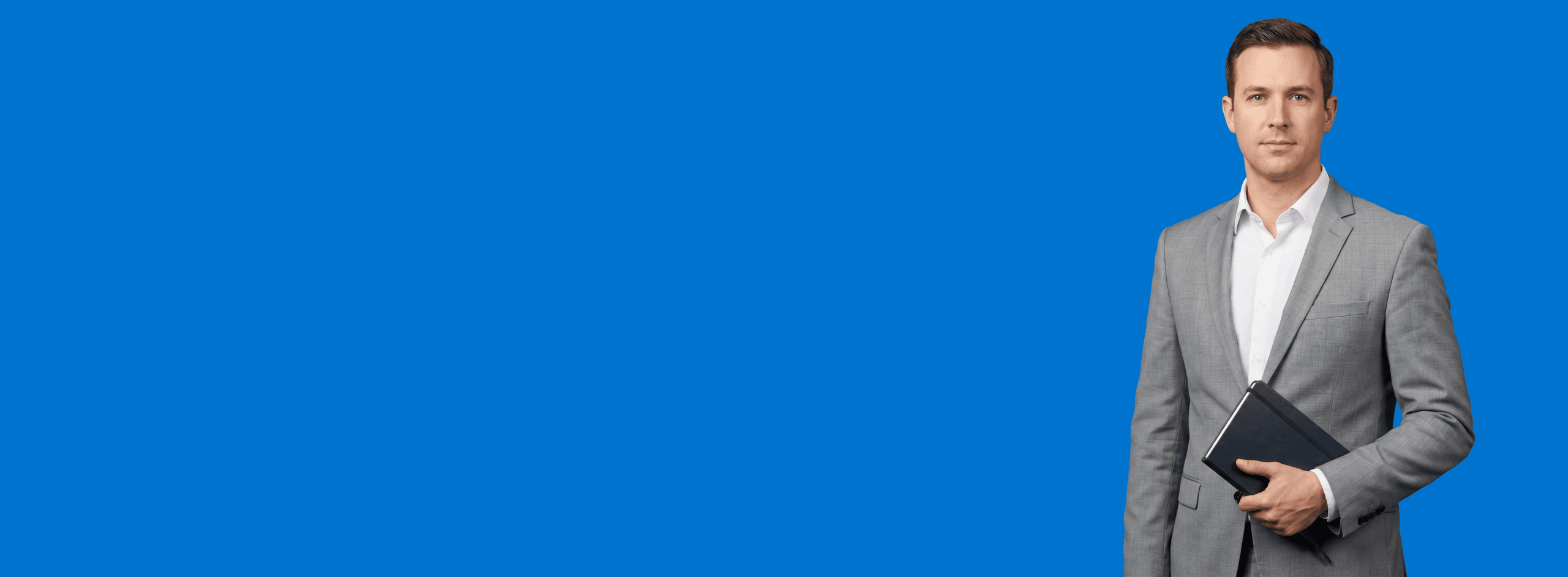 white male attorney, 30s, athletic build in light gray suit with white shirt, portrait against a saturated blue background - Marketing That Runs Without You
